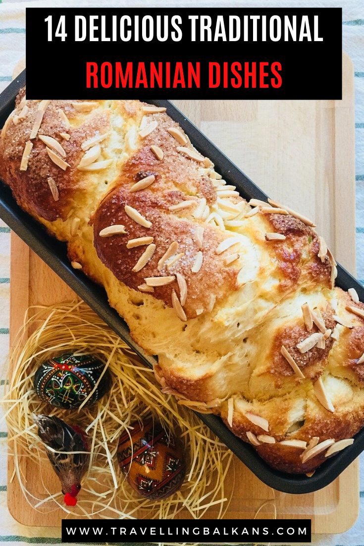 Romanian cozonac sweet bread topped with almonds and sugar, resting in a black loaf pan with painted Easter eggs beside it. Text overlay reads “14 Delicious Traditional Romanian Dishes.”