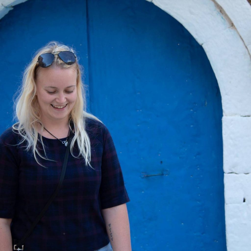 Anita in front of a blue door